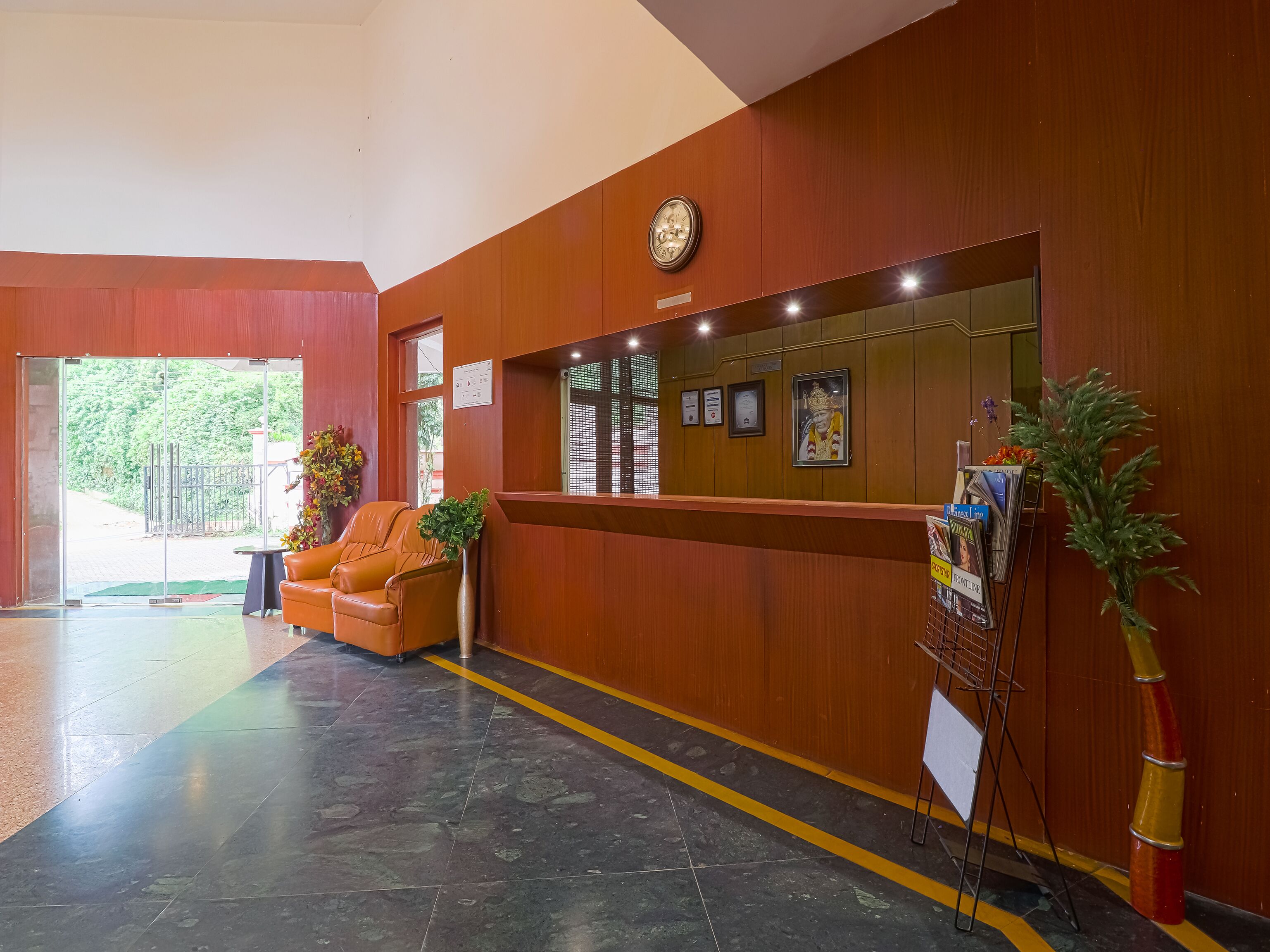 A reception area with a wooden reception desk, a seating area with chairs, and a glass door leading outside.