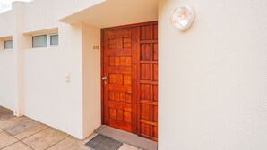 A wooden door with a number "205" on the wall beside it, a small window, and a wall-mounted light fixture. - FLH Funchal Ocean View with Pool (Funchal)