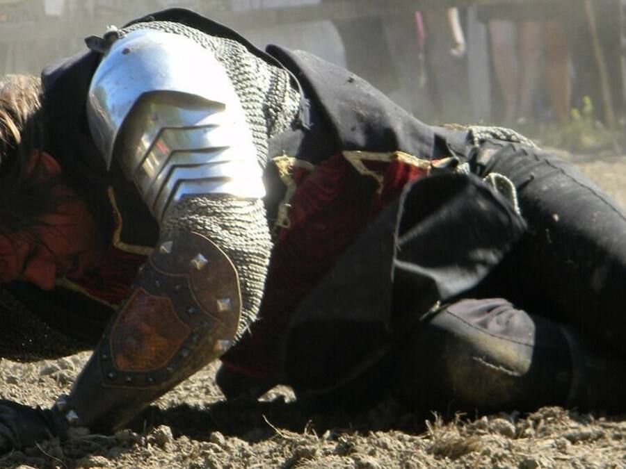 A person lying on the ground, wearing a helmet and protective gear.