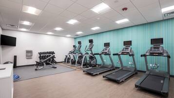 A gym with treadmills, elliptical machines, and weightlifting equipment.