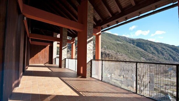 A covered walkway with a view of a mountainous landscape. - Alberg Les Estades (Rialp)
