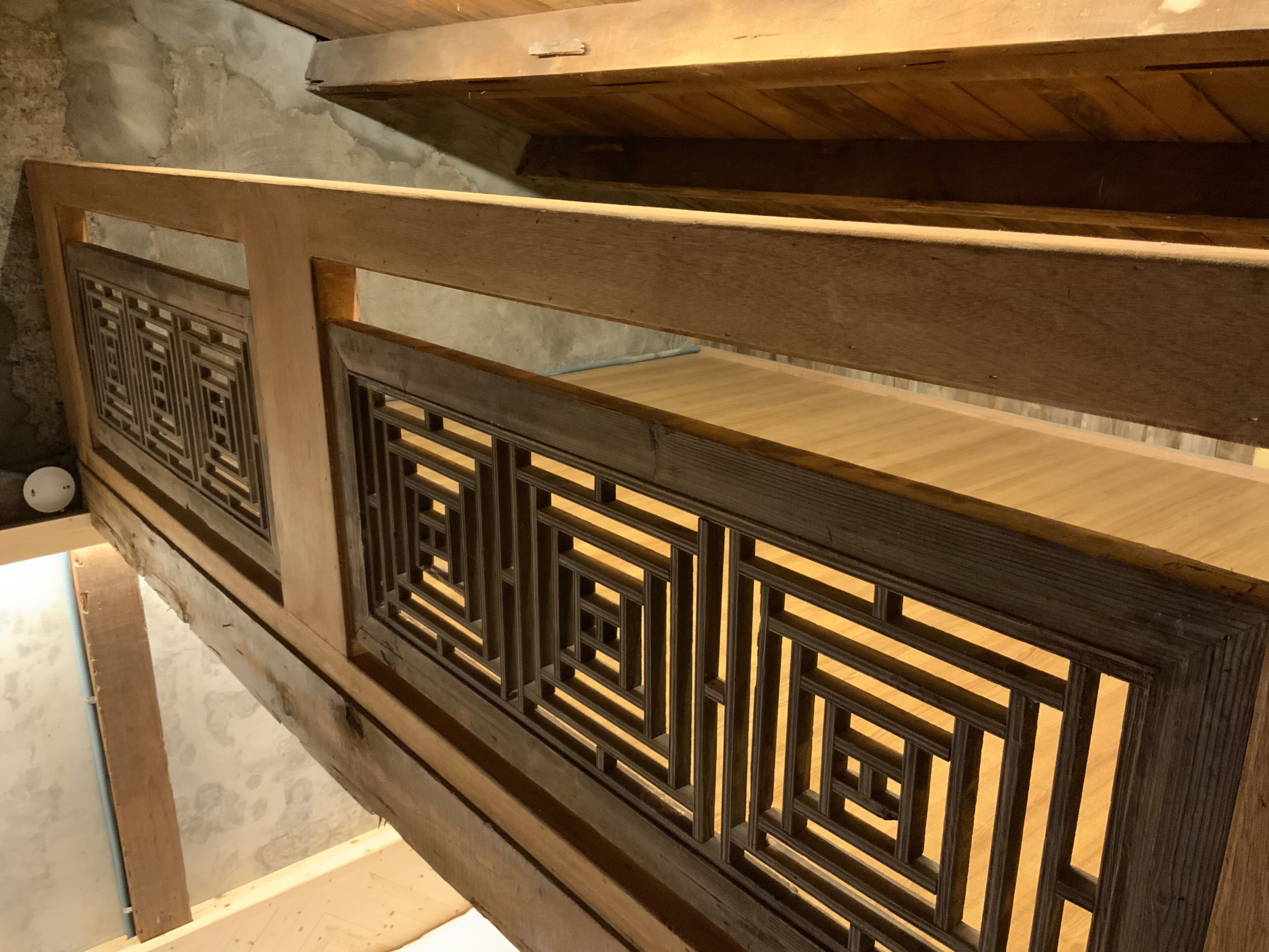 A wooden railing with intricate geometric patterns.