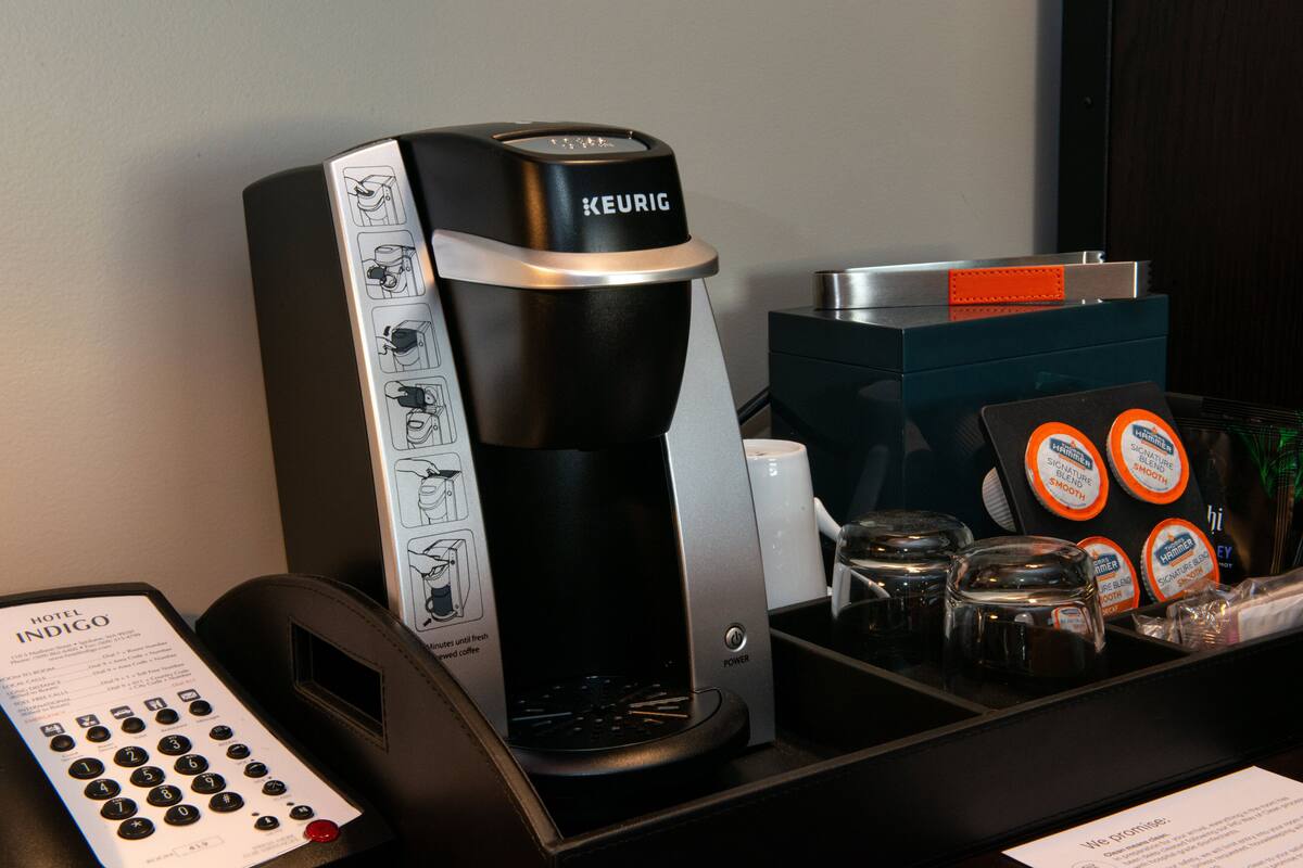 A Keurig coffee machine with a coffee pod holder and a coffee maker on a counter.