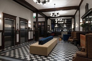 A lobby with a checkered floor, a central bench, and two elevators. - Hotel Indigo Spokane Downtown by IHG (Spokane)