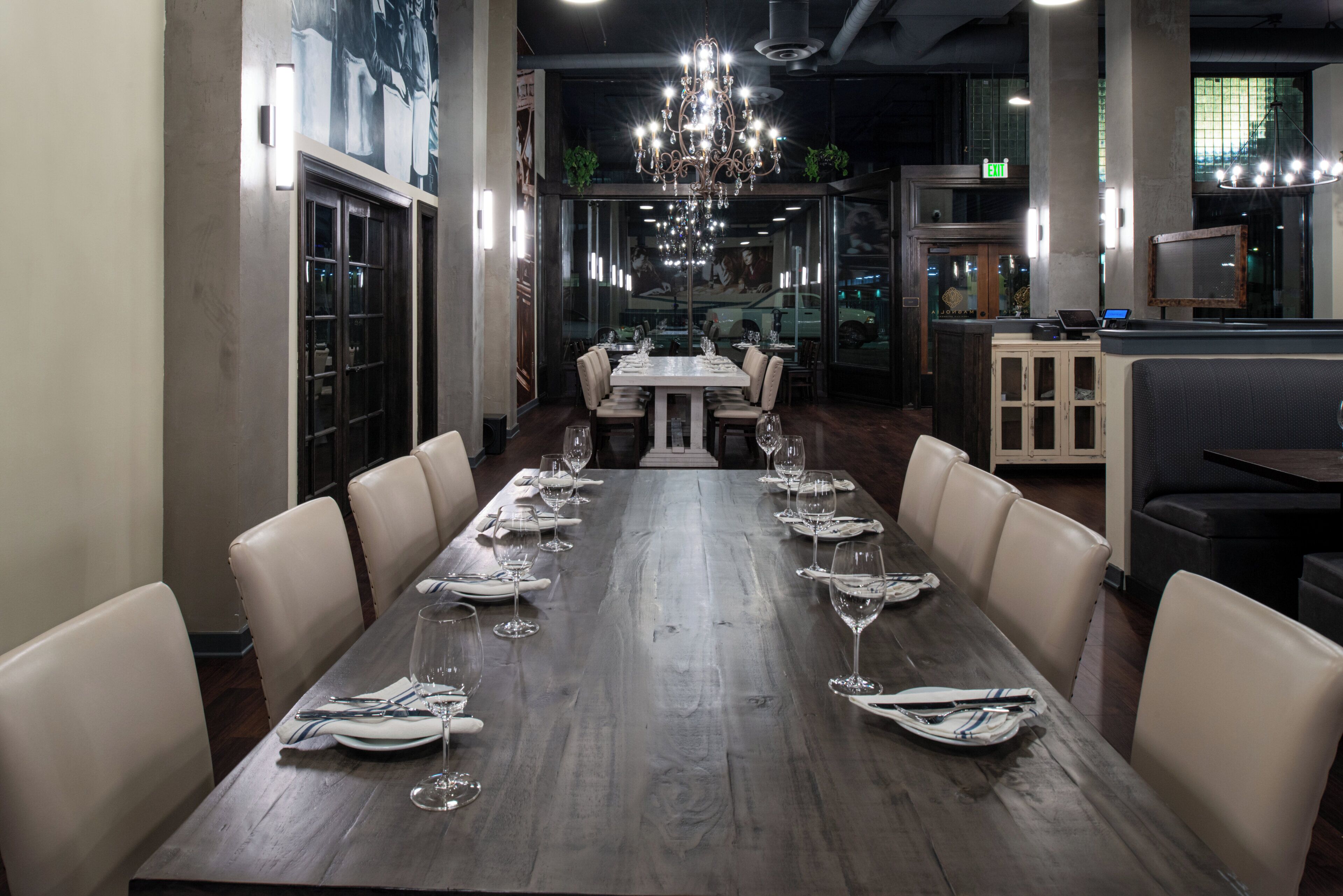 A restaurant with a long dining table set for a meal, surrounded by chairs.