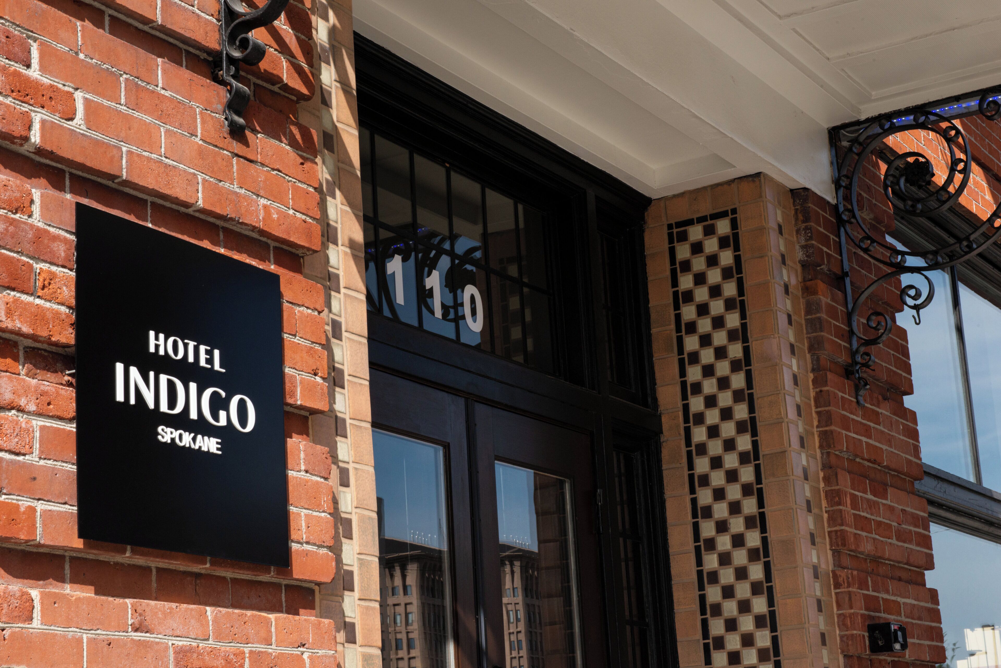 Une enseigne d’hôtel indiquant « Hotel Indigo Spokane » sur un bâtiment en briques.