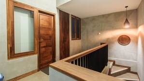 A staircase with wooden railings and a light fixture above. - Kuta Legian Villa (Kuta)