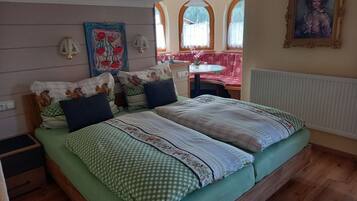 A bedroom with a bed, pillows, a desk, and a chair.