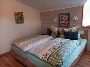 A bedroom with a bed, pillows, a headboard, wall art, and a window. - Tower room 2 - Waldheim House (Oetz)