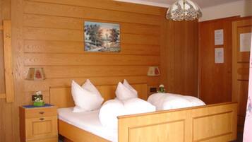 Ein Schlafzimmer mit Holzwänden, einem Bett, einem Nachttisch und einem Gemälde an der Wand.