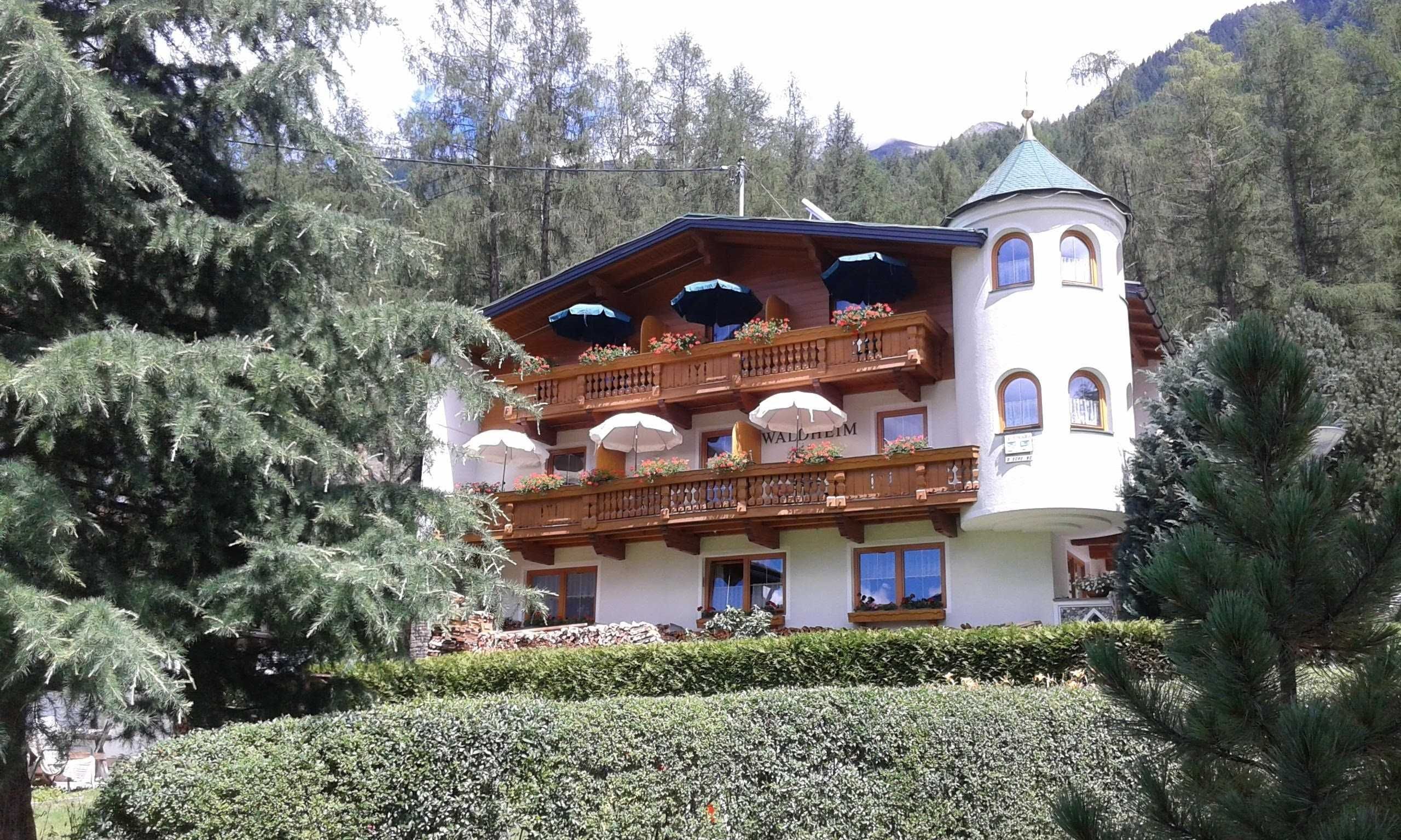 Ein mehrstöckiges Gebäude mit Balkonen und einem Turm, mit einem Schild, auf dem 'WALTHERM' steht.
