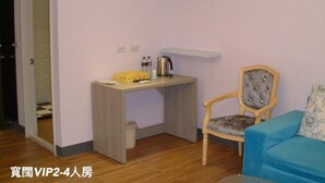 Una habitación pequeña con escritorio, silla y sofá azul.