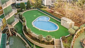 A rooftop pool with a surrounding green area and a small staircase leading to the pool. - Apartamento&piscina cerca de Barcelona (Ripollet)