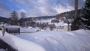 A snow-covered landscape with a ski resort, including ski lifts and buildings. - Ferienhotel Zwotatal (Klingenthal)