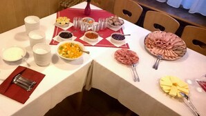 A table set for a meal with various dishes, including a bowl of soup, a plate of sliced meat, and several bowls of condiments. - Ferienhotel Zwotatal (Klingenthal)