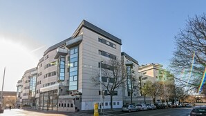 Ein mehrstöckiges Gebäude mit modernem architektonischen Design, das große Fenster und ein Flachdach aufweist.