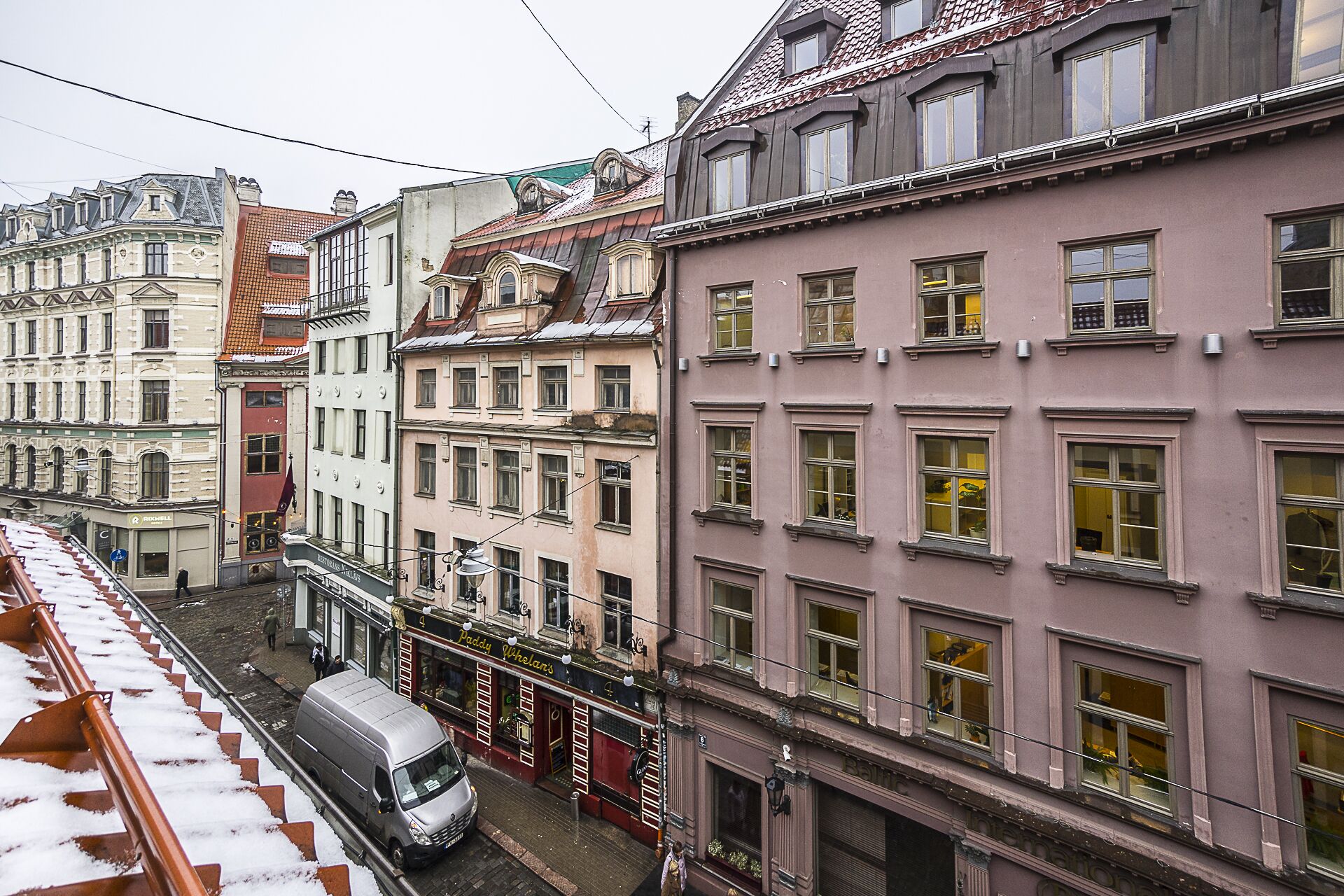 Una hilera de edificios históricos con patrones de ventanas uniformes y una calle central.