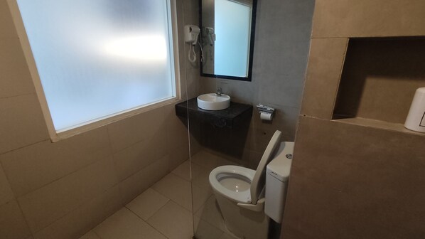 Un baño pequeño con inodoro, lavamanos y espejo.
