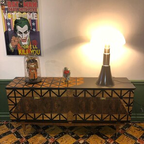 Relax in a stylish room with a console table, display case, and unique lamp.
