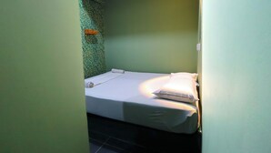 A small, single-bed room with a green textured wall and a white bedspread. - Healthy Home, Changkat Bukit Bintang (Kuala Lumpur)