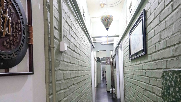A narrow hallway with brick walls, framed pictures, and a tiled floor. - Healthy Home, Changkat Bukit Bintang (Kuala Lumpur)