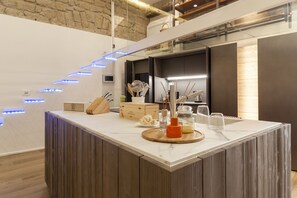A modern kitchen with a marble countertop, wooden accents, and under-cabinet lighting. - Hidden Gem (Naples)