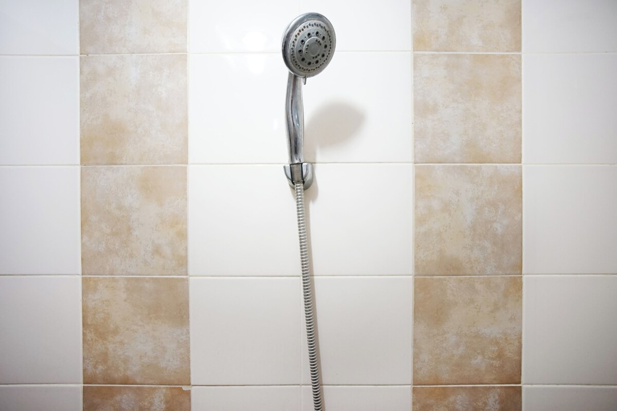 Een douche met een handdouche.