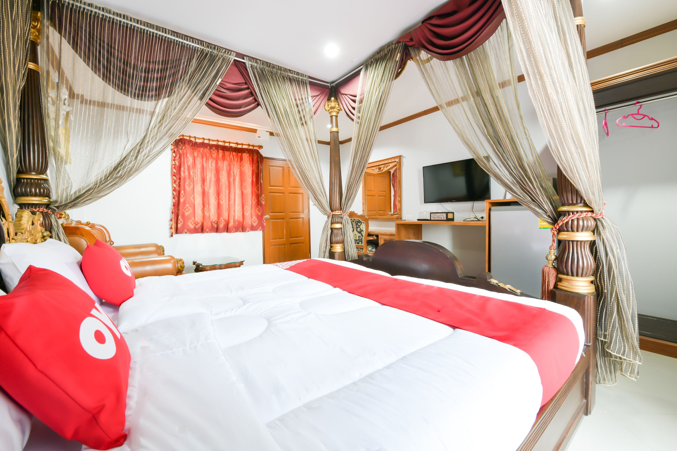 Ein geräumiges Schlafzimmer mit einem großen Bett, einem Schreibtisch und einem Fernseher.