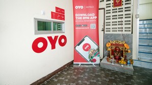 A hotel entrance with a large OYO Hotels sign, a QR code for the OYO app, and a small shrine with offerings. - OYO 525 MRT Phetkasem 48 Place (Bangkok)