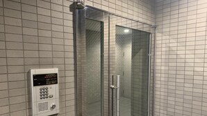 A glass-enclosed shower stall with a control panel on the wall. - OUCHI HOTEL Dambara (Hiroshima)