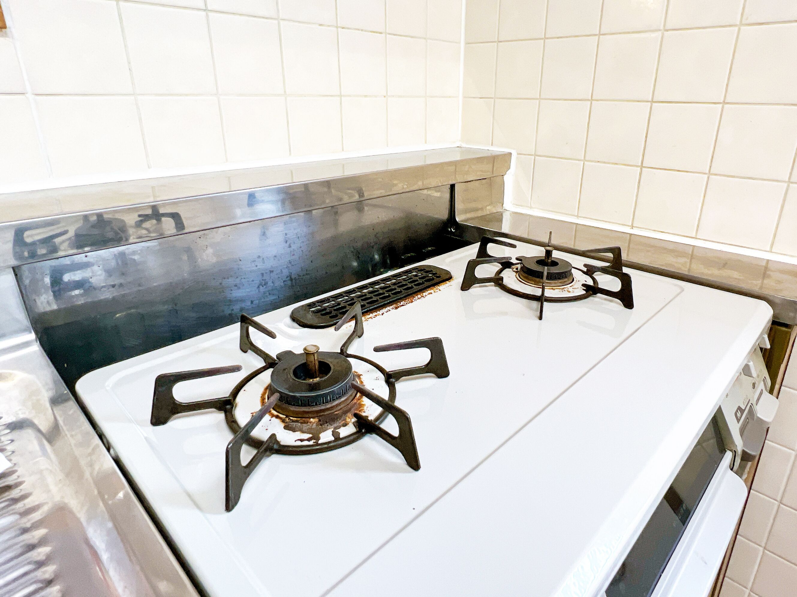 A kitchen with a white stove top and two burners.