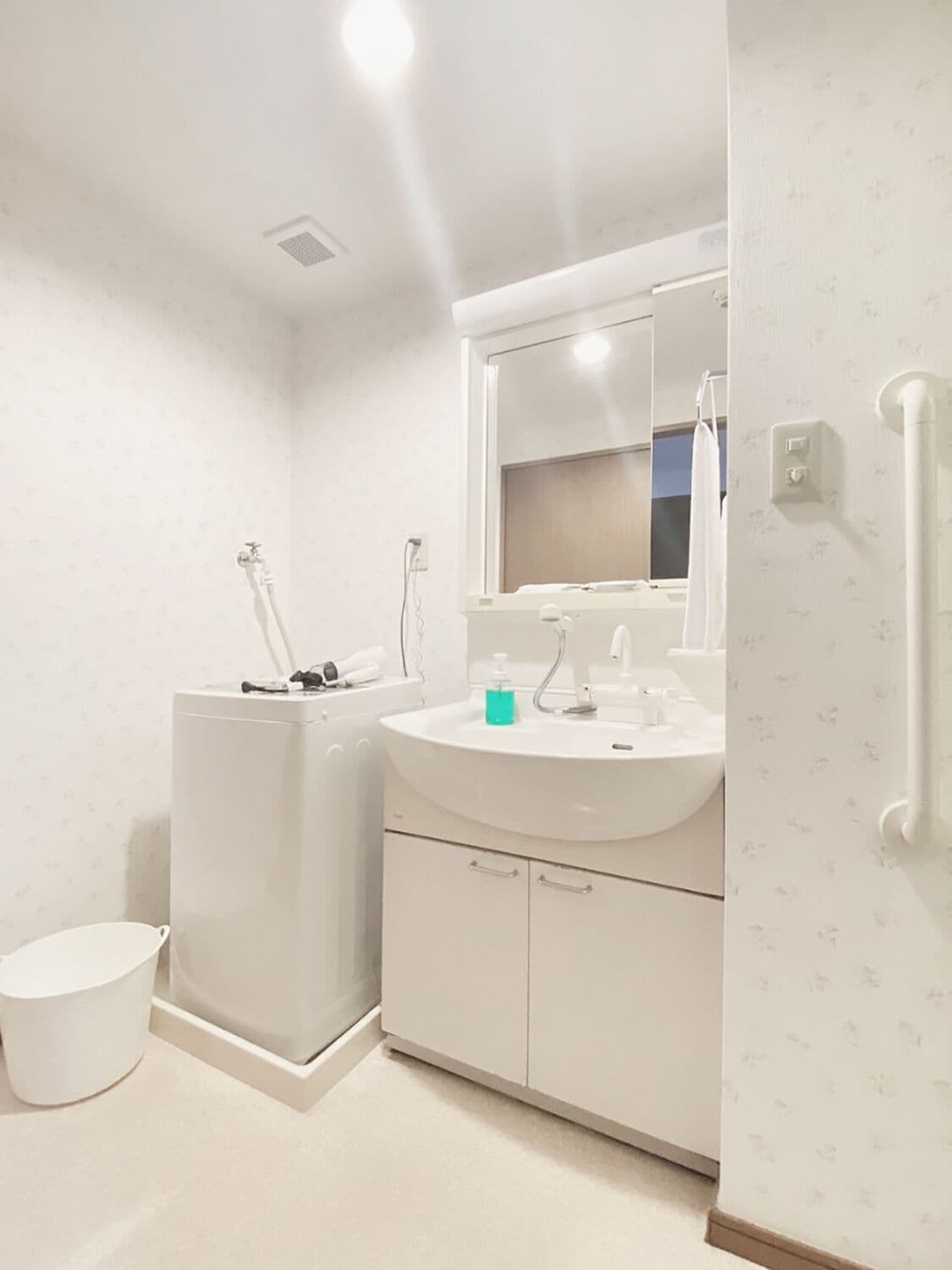A modern bathroom with a white sink, mirror, and toilet.