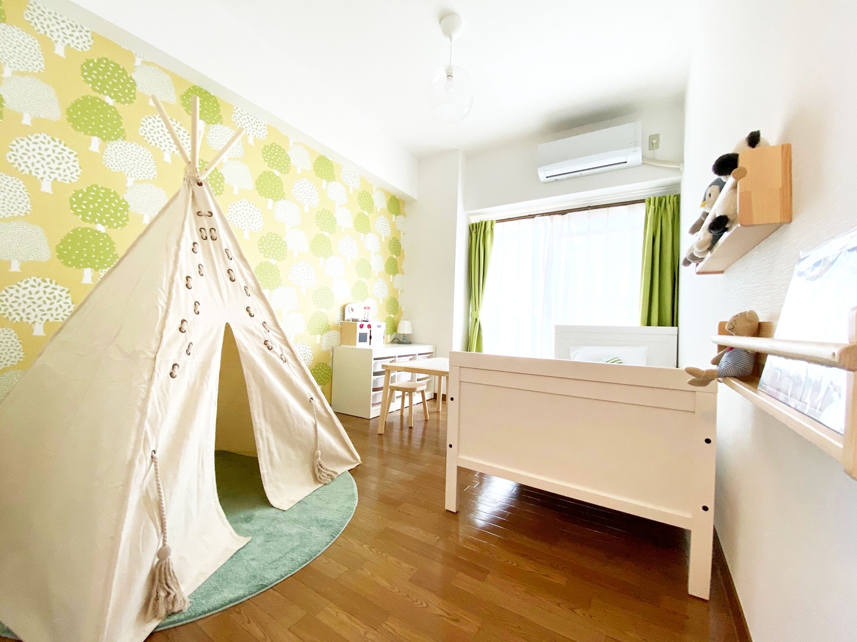A child-friendly room with a bed, a small desk, a chair, a tent, and a window with curtains.