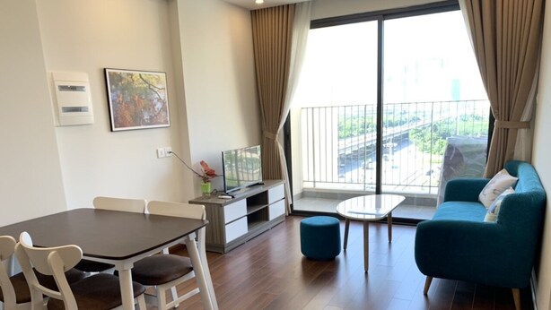 Una sala de estar moderna con una mesa de comedor, sillas, un sofá y una pequeña mesa redonda.