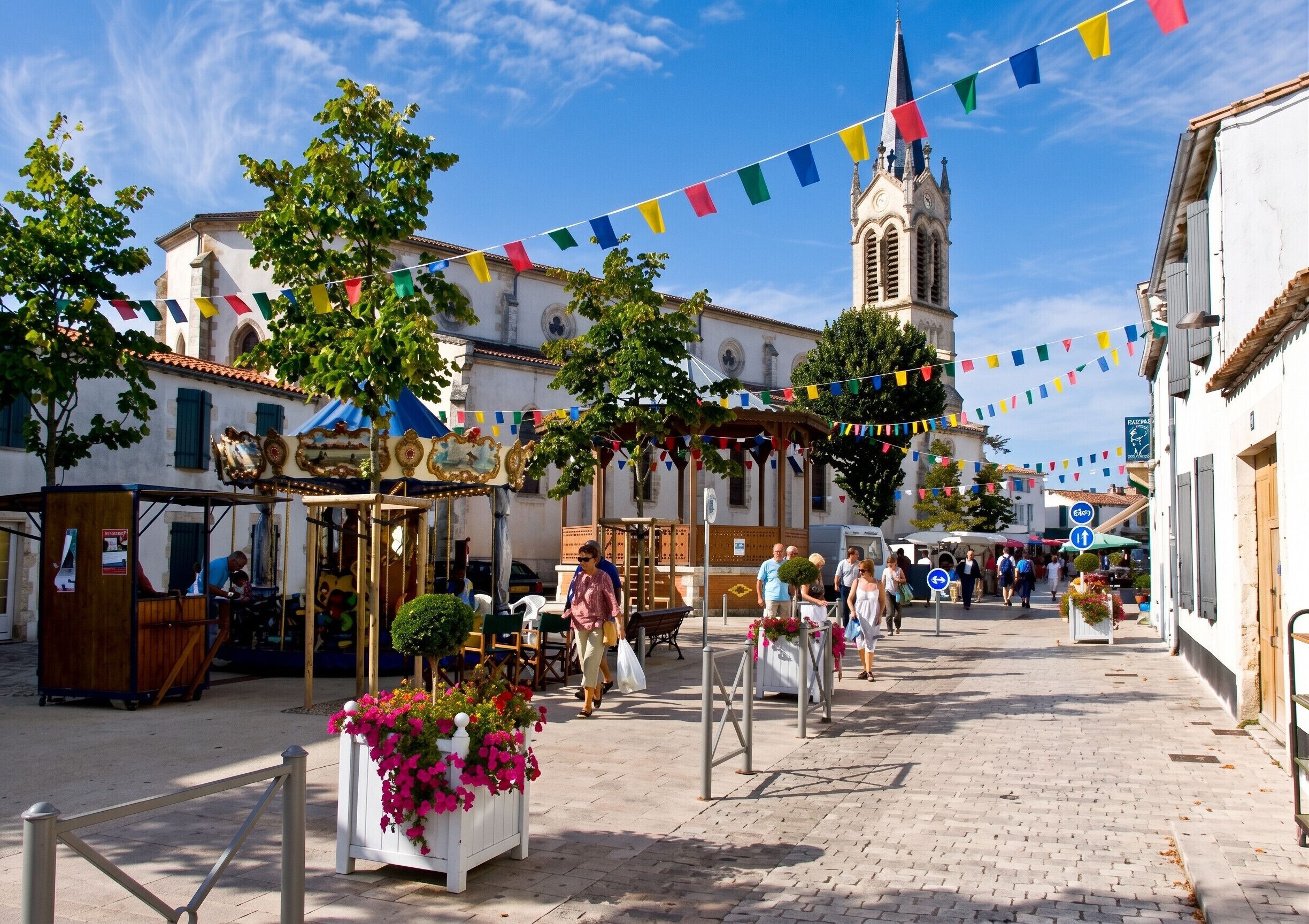 A cobblestone street with buildings, a church, and colorful flags.