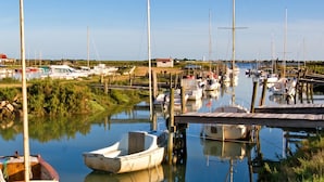 A marina with multiple boats docked, surrounded by greenery and a clear sky. - Homerez - House in La Couarde-sur-Mer (La Couarde-sur-Mer)