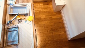 A modern kitchen with a gas stove, microwave, and stainless steel range hood. - 3 Bedroom Apartments Wells Street (London)