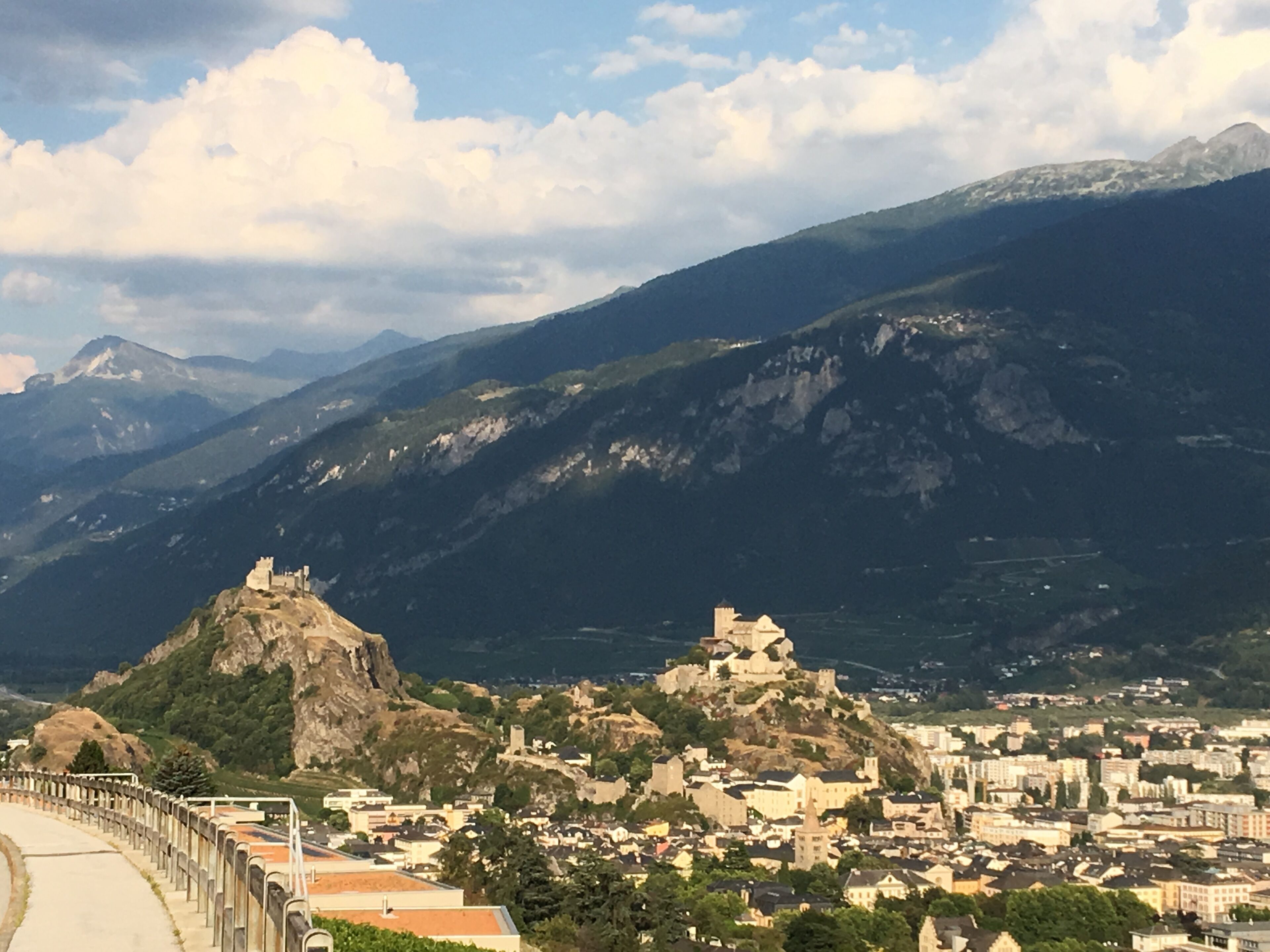 A mountainous town with historic buildings and a prominent castle on a hill.