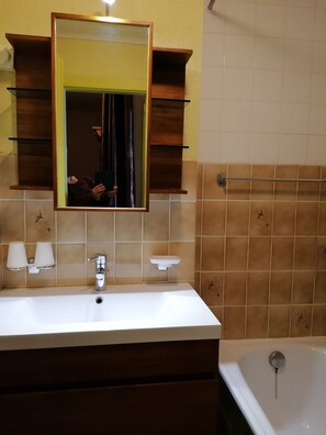 A bathroom with a white sink, a mirror, and a bathtub. There are two towel racks above the sink and a towel rack next to the bathtub. - IRIS Apartment "Vacation Rental in Veysonnaz, 4 Valleys" (Veysonnaz)