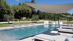 A rectangular swimming pool with clear blue water, surrounded by lounge chairs and a canopy. - Luxury vacation rental SALON DE PROVENCE LS7-351 (Salon-de-Provence)