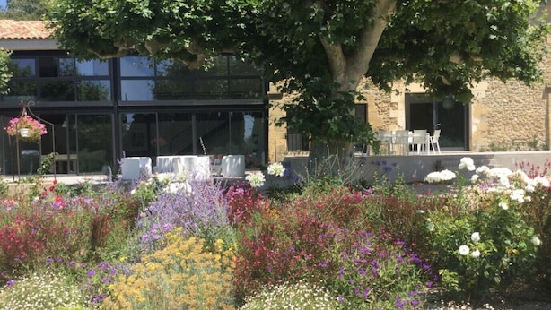 A garden with various flowers and a building with outdoor seating. - Luxury vacation rental SALON DE PROVENCE LS7-351 (Salon-de-Provence)