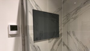 A bathroom with a digital thermostat, a large mirror, and marble tiles. - Luxury 2 Bed 2 Bath Apartments next to kings cross (London)