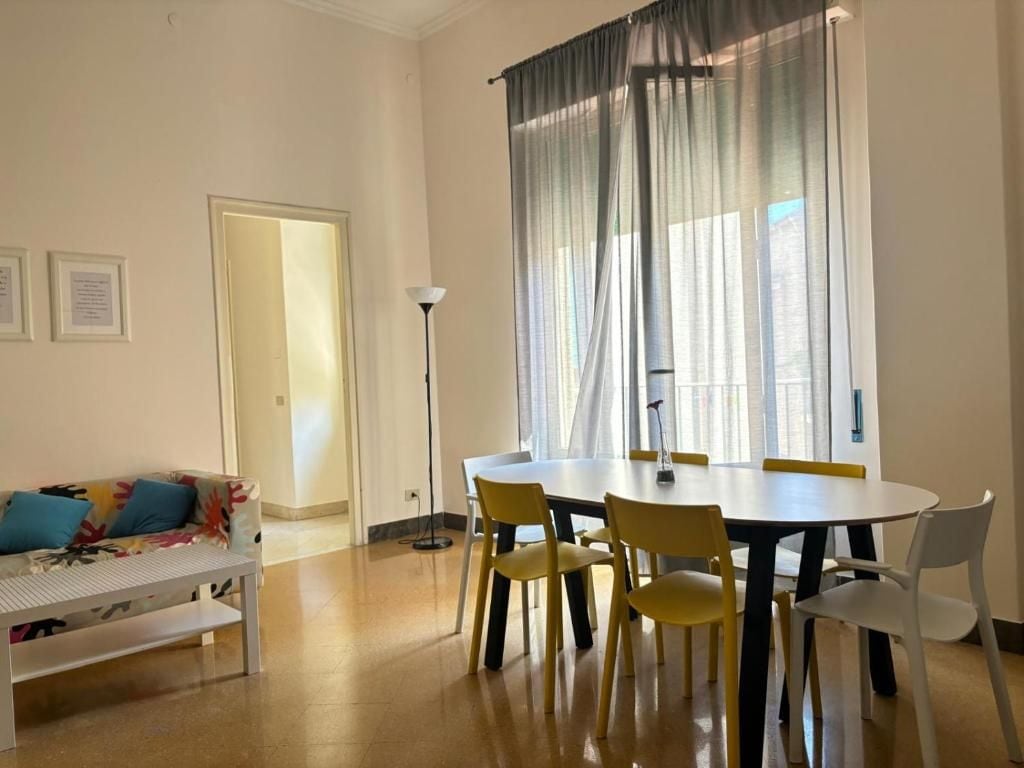 Una habitación con una mesa de comedor, sillas, un sofá y una lámpara de pie.