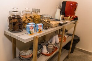 A kitchen counter with jars of snacks, a coffee maker, and various kitchenware. - Mamamia City (Palermo)