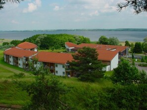 A residential area with multiple houses, a lake in the background, and a road in the foreground. - Ferienland Salem (Malchin)