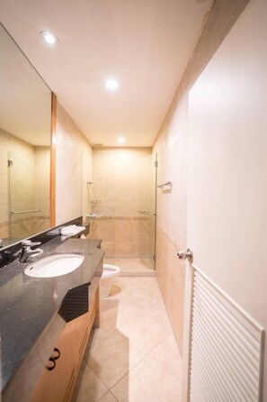 Une salle de bain moderne avec un grand miroir, deux lavabos et un espace douche.