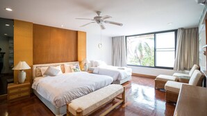 A hotel room with a large bed, a smaller bed, a bench, a chair, a ceiling fan, and a window with curtains. - Dojo pool villa beach front and sea view (Unknown)