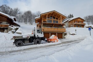 Una carretera cubierta de nieve con una máquina quitanieves y un camión.