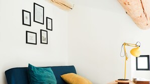 A modern living room with a blue sofa, a yellow lamp, and a wooden coffee table. - La Grange 1832 - 10 mins from Aubenas (Saint-Étienne-de-Boulogne)