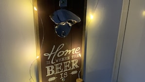 Une tireuse à bière murale avec les inscriptions « Ouvrir les bouteilles ici » et « Chez nous, la bière coule à flots ».